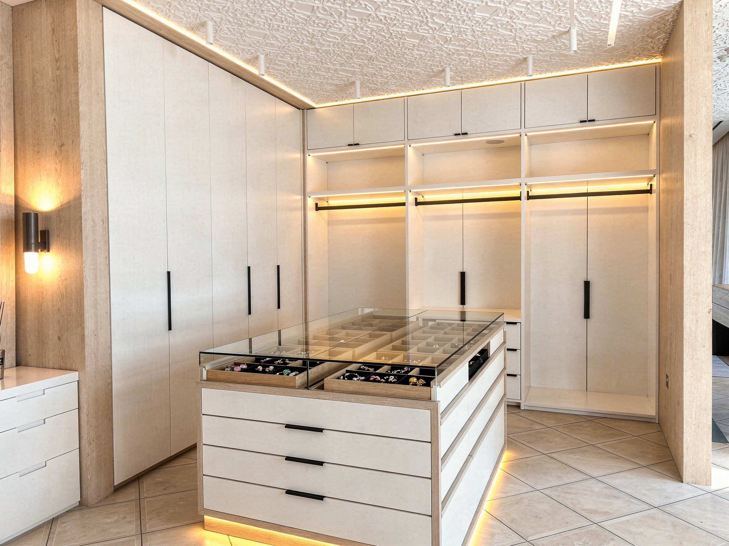 Walk-in dressing room with fitted wardrobes, island and integrated lighting by Mistry Interiors