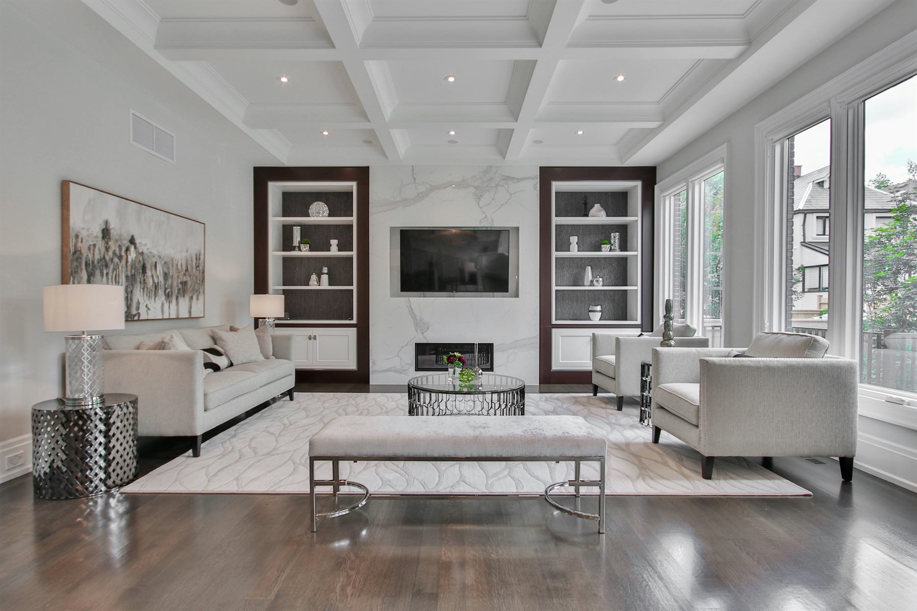 Coffered ceiling living room with built-in joinery and marble fireplace by Mistry Interiors, Dubai